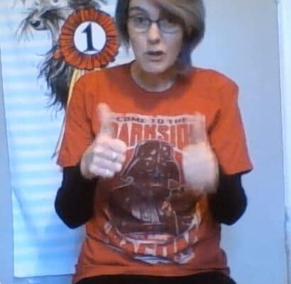 Anne doing online storytime, wearing a Star Wars Darth Vader tshirt: welcome to the dark side, we have bacon.