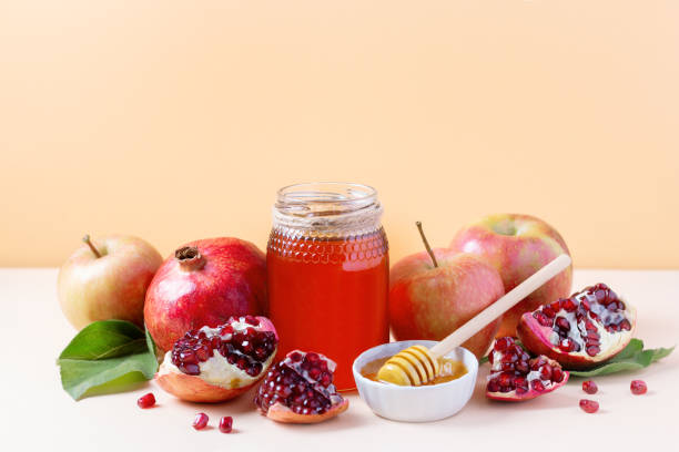 Apples, jar of honey and pomegranates on tray for Jewish holiday Rosh Hashanah.