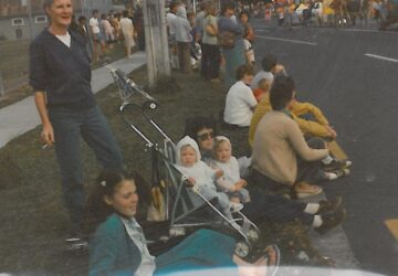 A 1980s family watching a parade in Aotearoa. 